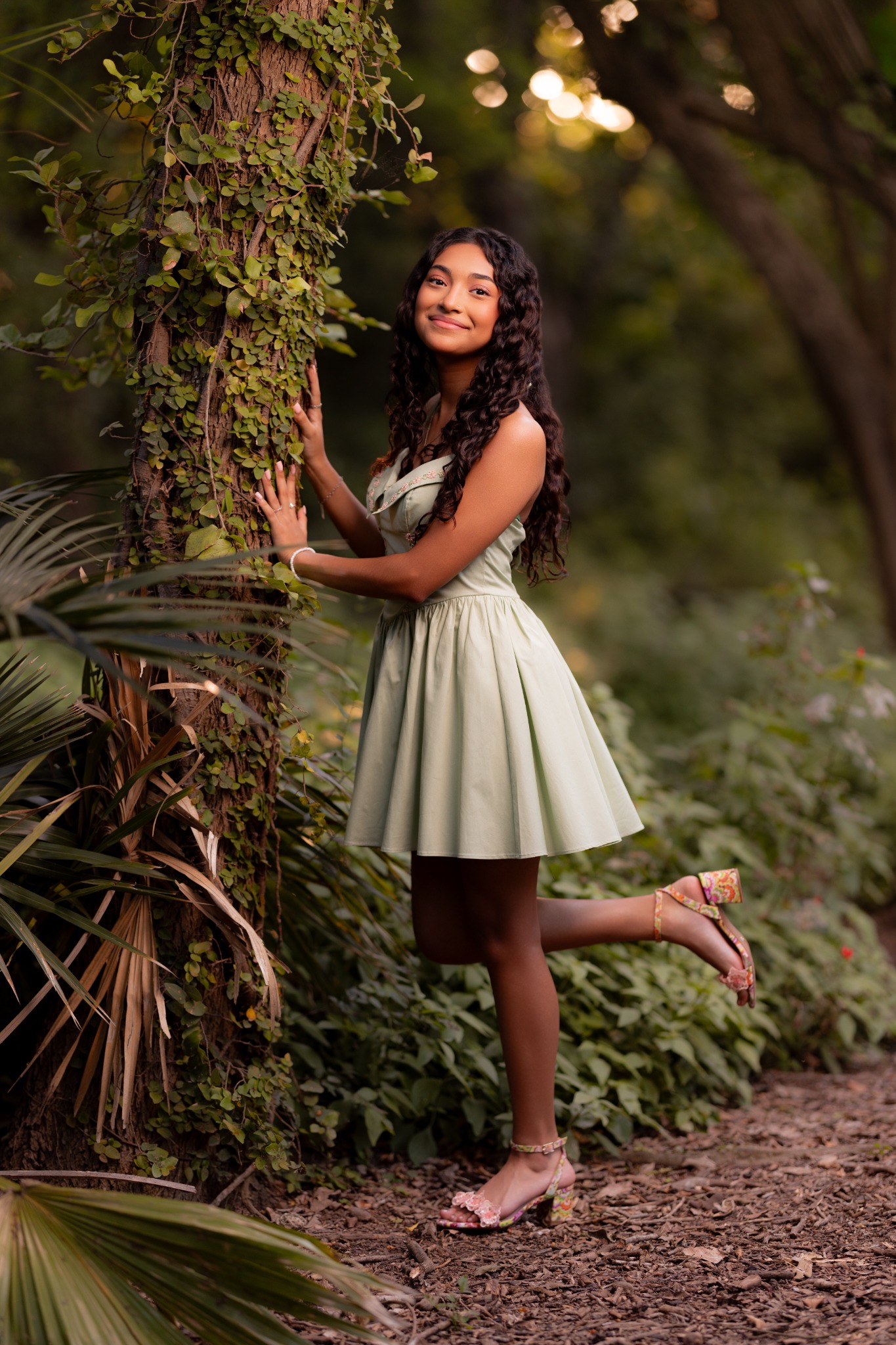 Camila posing beside a tree